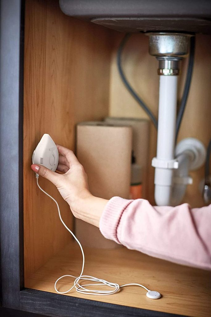 women installing a moen smart leak detector