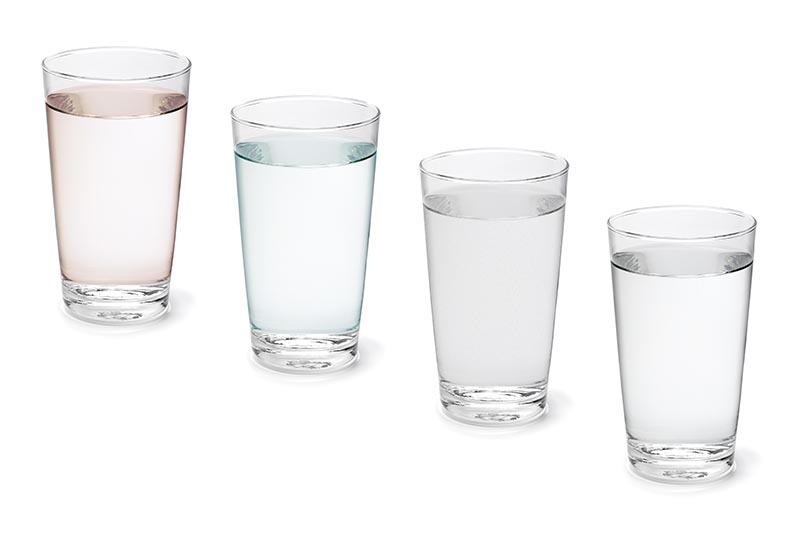 s clear drinking glasses filled with liquids, arranged diagonally against a plain white background.